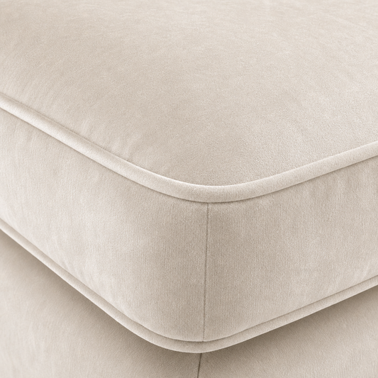 Close-up of a cream velvet sofa with a soft texture