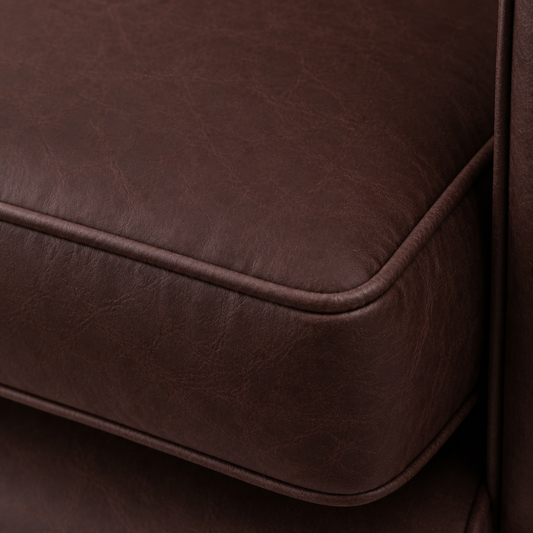 Close-up of a brown leather ottoman corner
