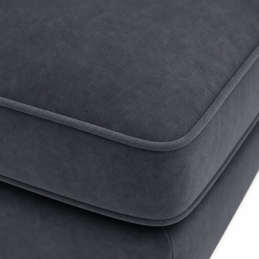 Close-up of a dark charcoal gray upholstered cushion with rounded edges and a soft suede-like texture, shown against a white background.