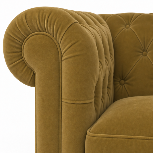 Close-up of a classic Chesterfield armchair upholstered in a textured mustard yellow velvet fabric, featuring a tufted rolled arm and button-tufted backrest.