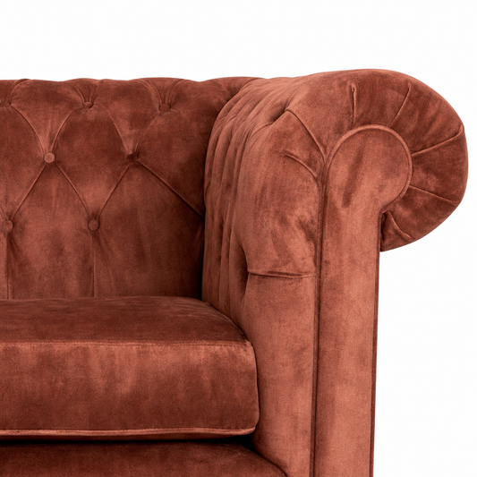 Orange velvet sofa with tufted backrest on a white background