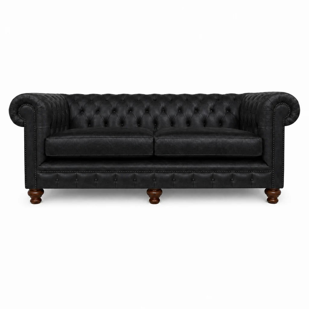 Black leather sofa with tufted backrest on a white background