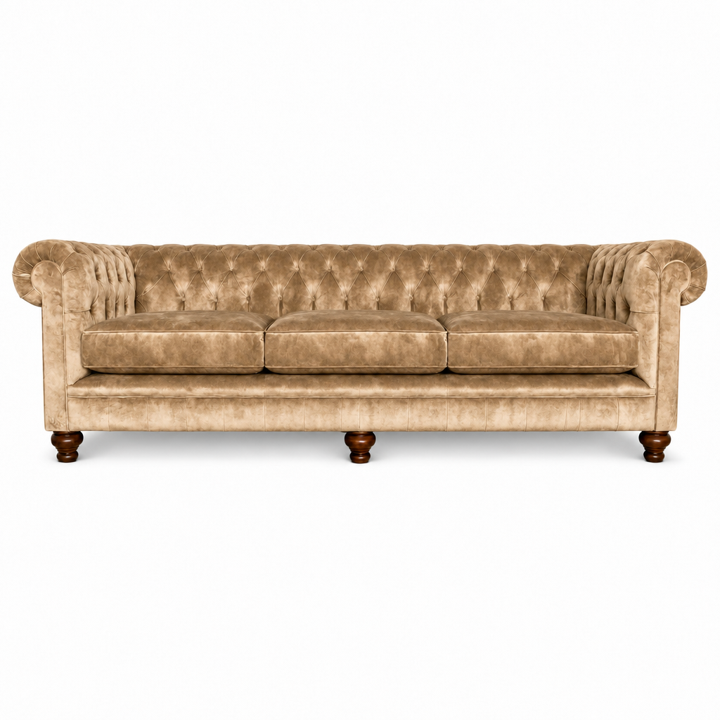 A classic Chesterfield three-seater sofa upholstered in beige velvet, featuring deep button tufting, rolled arms, and dark brown wooden legs, shown against a plain white background.
