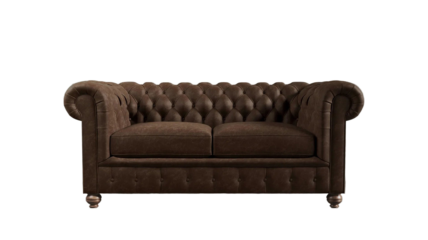 Brown leather chesterfield sofa against a textured wall.