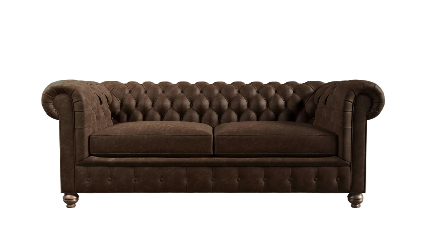 Brown leather chesterfield sofa against a textured wall.