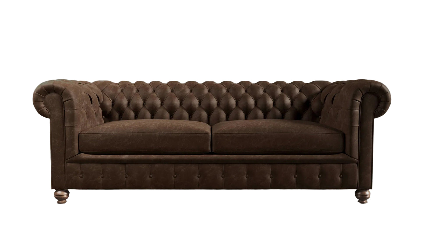 Brown leather chesterfield sofa against a textured wall.