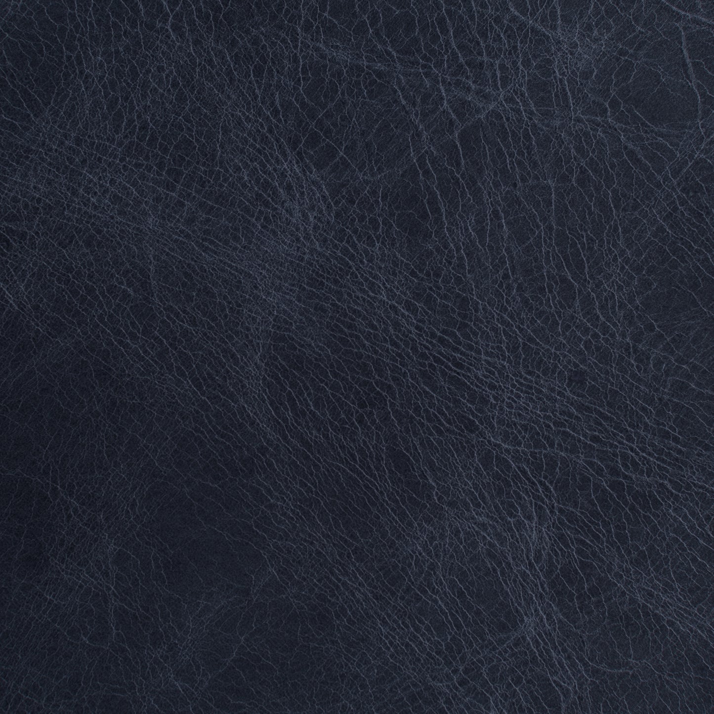 A close-up texture shot of dark navy blue leather with fine grain lines.