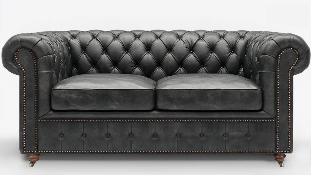 Grey leather chesterfield sofa on a white background