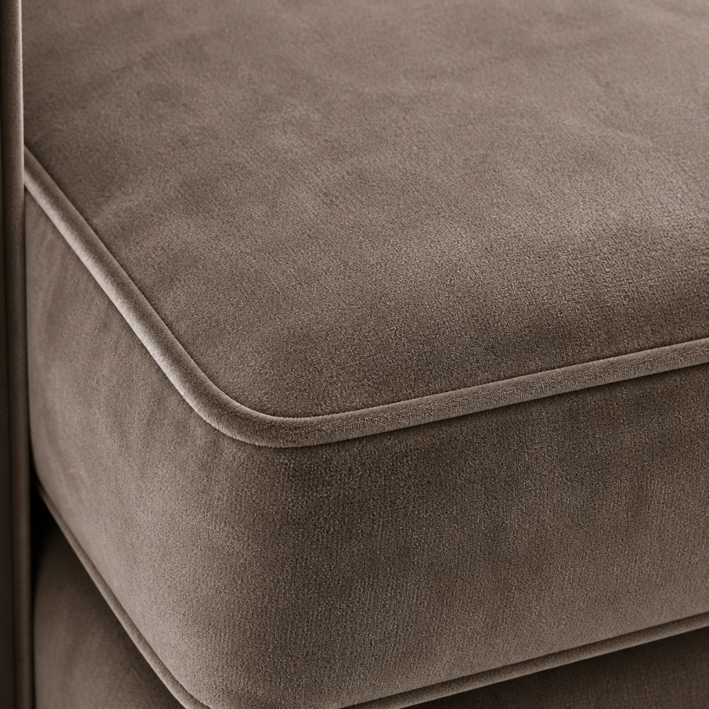 Close-up of a grey velvet upholstered sofa seat with visible stitching