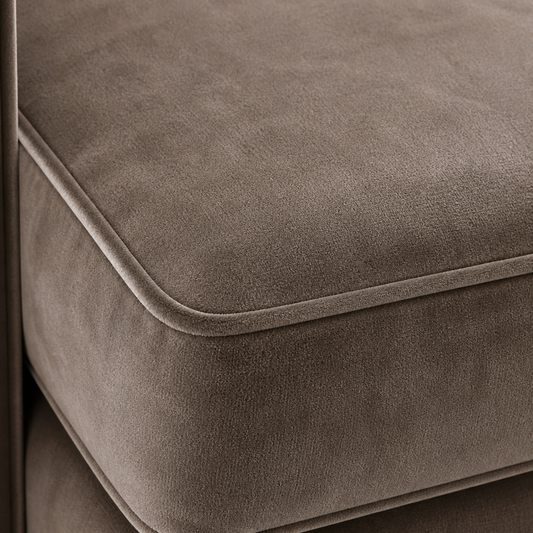 Close-up of a grey velvet upholstered sofa seat with visible stitching