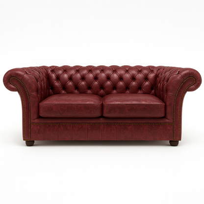 Red British leather chesterfield sofa with tufted backrest on a white background