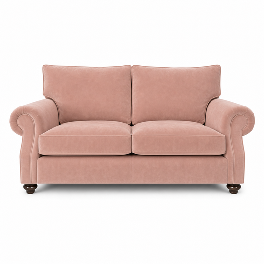 A classic two-seater loveseat sofa upholstered in dusty rose pink velvet, featuring rolled arms, dark wooden feet, and a clean silhouette, shown against a plain white background.