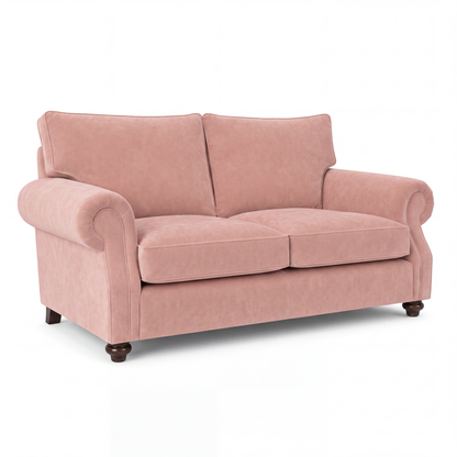 A classic two-seater loveseat sofa upholstered in dusty rose pink velvet, featuring rolled arms, two back cushions, two seat cushions, and dark brown wooden legs, shown on a plain white background.