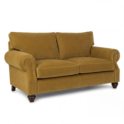 A classic two-seater loveseat sofa upholstered in a textured mustard yellow velvet fabric, featuring rolled arms, dark brown turned wood legs, and a clean studio background.