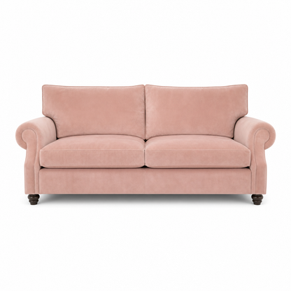 A two-seater loveseat sofa upholstered in dusty pink velvet, featuring rolled arms, two back cushions, two seat cushions, and dark turned wood legs, shown against a plain white background.