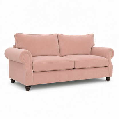 A classic two-seater loveseat sofa upholstered in dusty pink velvet, featuring rolled arms, dark wooden turned legs, and a clean silhouette, shown against a plain white background.