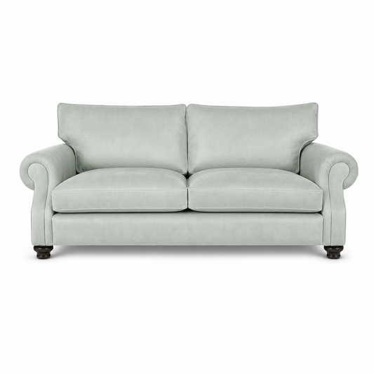 A light sage green upholstered loveseat with rolled arms, two back cushions, two seat cushions, and dark wooden legs, shown against a plain white background.