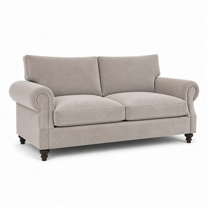 A classic two-seater loveseat sofa upholstered in a textured light beige fabric, featuring rolled arms, dark wooden turned legs, and a clean silhouette on a white background.