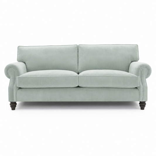 A two-seater loveseat sofa upholstered in a light sage green fabric, featuring dark turned wooden legs, shown against a plain white background.