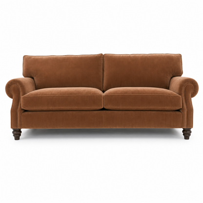 A classic two-seater loveseat sofa upholstered in a warm brown velvet fabric, featuring rolled arms, dark turned wooden legs, and a clean silhouette on a white background.