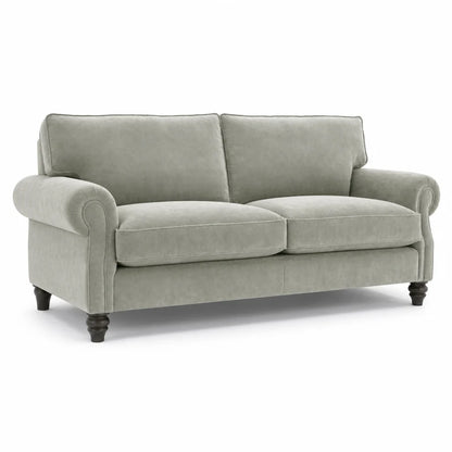 A light sage green upholstered loveseat with rolled arms, two back cushions, two seat cushions, and dark turned wooden legs, shown on a plain white background.