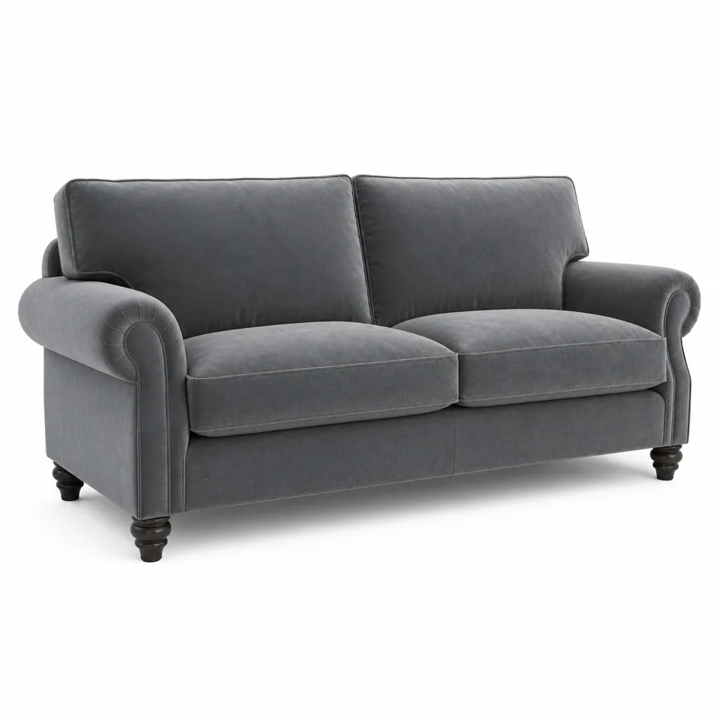 A dark gray velvet loveseat sofa with rolled arms, two back cushions, two seat cushions, and dark turned wooden legs, shown on a plain white background.