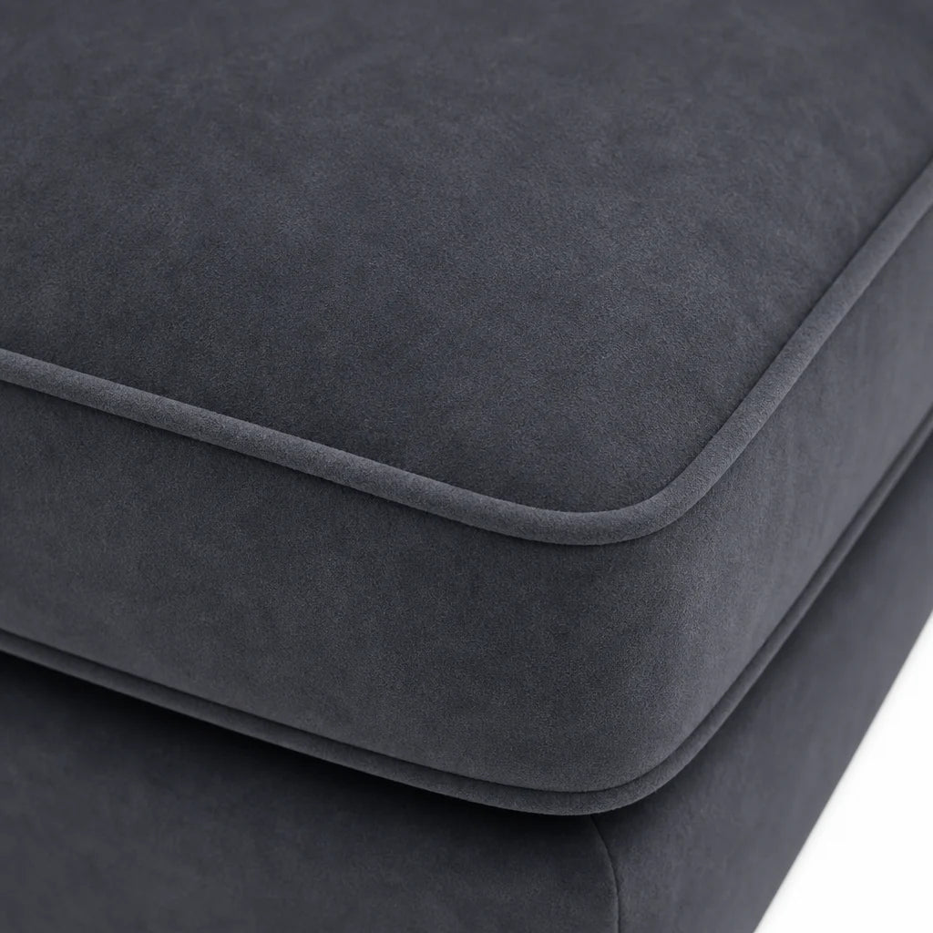 Close-up of a dark charcoal gray upholstered cushion with rounded edges and a soft suede-like texture, shown against a white background.