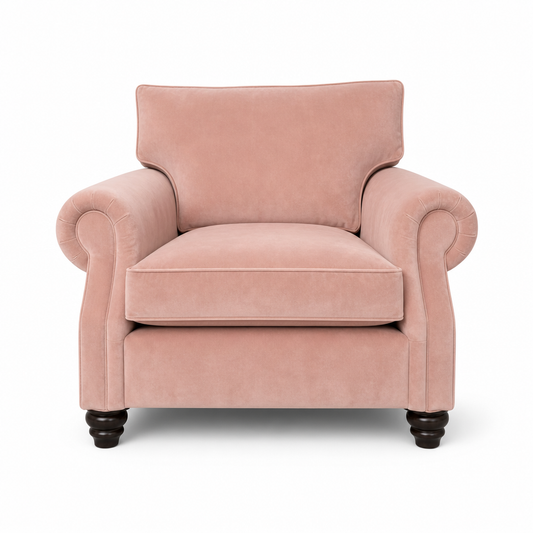A classic pink velvet armchair with rolled arms, a high backrest, and dark wooden turned legs, shown against a plain white background.