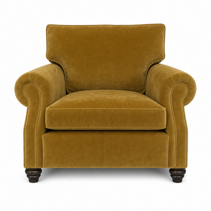 A classic armchair upholstered in a rich mustard yellow velvet fabric, featuring rolled arms, a high backrest, and dark turned wood legs, shown against a plain white background.