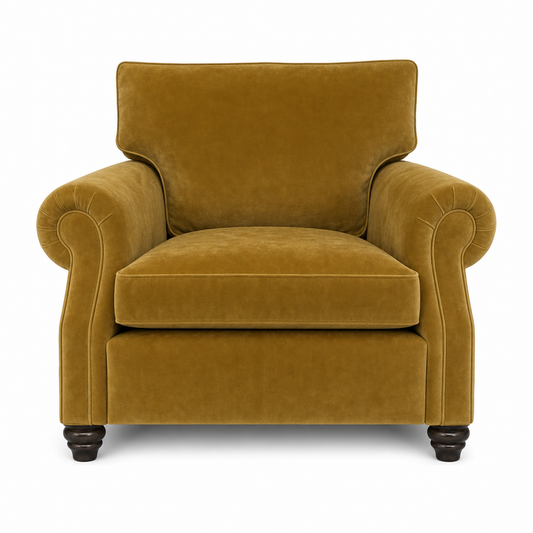 A classic armchair upholstered in a rich mustard yellow velvet fabric, featuring rolled arms, a high backrest, and dark turned wood legs, shown against a plain white background.