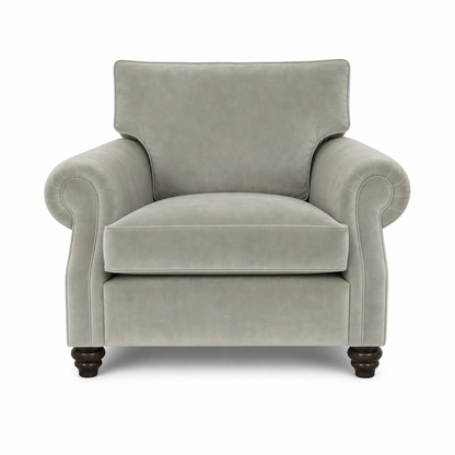 A classic upholstered armchair in a light gray fabric, featuring rolled arms, a high backrest, and dark turned wooden legs, shown against a plain white background.