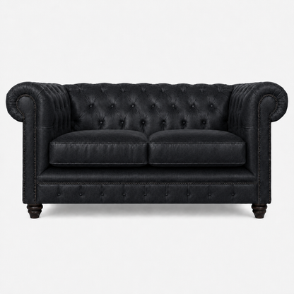 Black leather sofa with tufted backrest on a white background