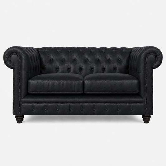 Black leather sofa with tufted backrest on a white background