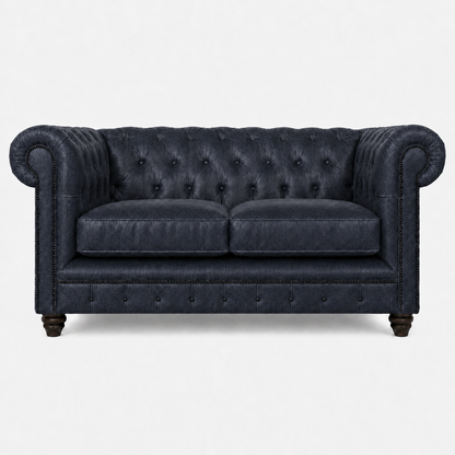 Blue velvet sofa with tufted backrest on a white background
