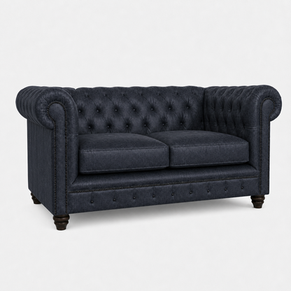 Dark blue tufted sofa on a white background