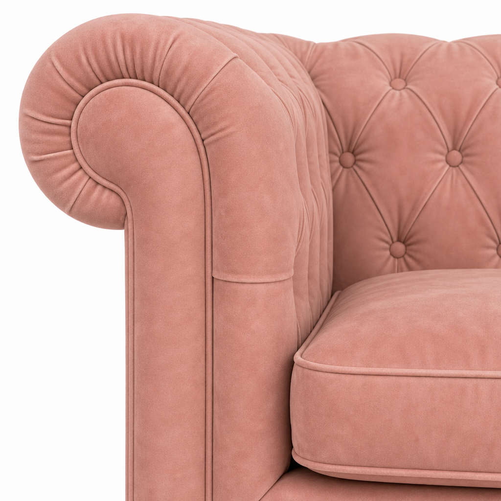 Close-up of a dusty pink velvet Chesterfield armchair showing the tufted backrest, rolled armrest, and cushion against a plain white background.
