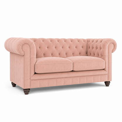 A classic Chesterfield loveseat sofa upholstered in dusty pink velvet, featuring a tufted button backrest, rolled arms, two seat cushions, and dark wooden legs, shown against a plain white background.