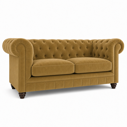 A classic Chesterfield loveseat sofa upholstered in a warm mustard yellow velvet fabric, featuring deep button tufting on the backrest and seat cushions, rolled arms, and dark wooden legs, shown against a plain white background.