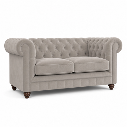 A classic Chesterfield loveseat sofa upholstered in a light beige textured fabric, featuring deep button tufting, rolled arms, two loose seat cushions, and dark brown turned wooden legs, shown against a plain white background.