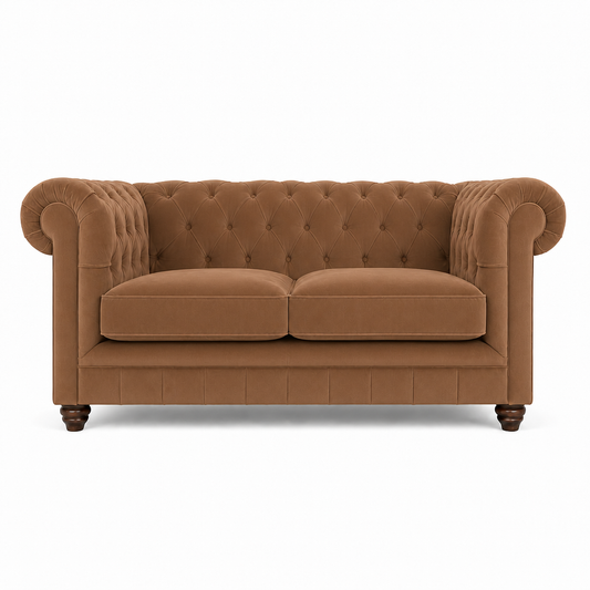A classic Chesterfield loveseat sofa upholstered in a warm camel brown fabric, featuring deep button tufting on the backrest, rolled arms, two loose seat cushions, and dark wooden legs, shown against a plain white background.