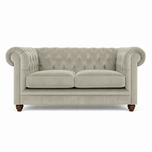 A classic Chesterfield loveseat sofa upholstered in a light beige textured fabric, featuring a tufted backrest, rolled arms, two seat cushions, and dark brown wooden legs, shown against a plain white background.