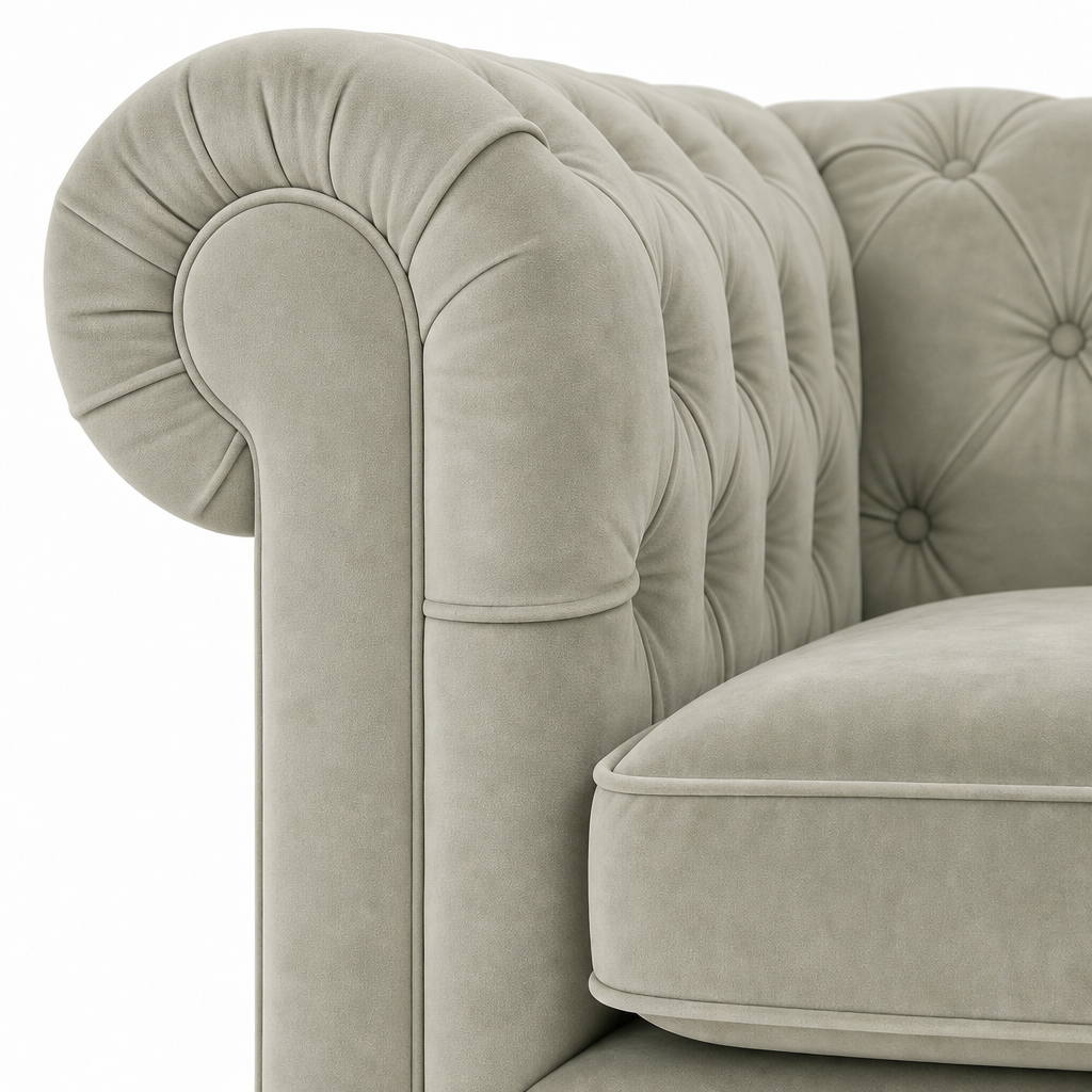 Close-up of a classic Chesterfield armchair upholstered in light sage green velvet, showing the tufted backrest and rolled armrest against a white background.