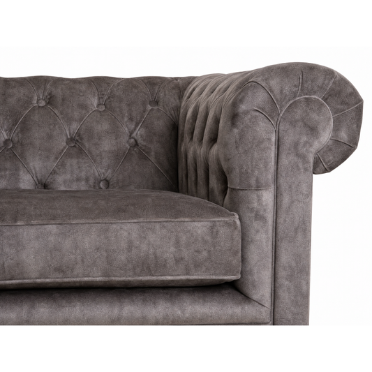 Gray velvet sofa with tufted backrest on a white background
