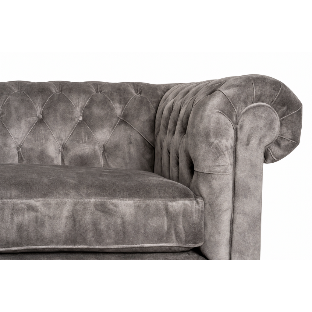 Gray velvet sofa with tufted backrest on a white background