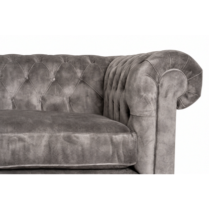 Gray velvet sofa with tufted backrest on a white background