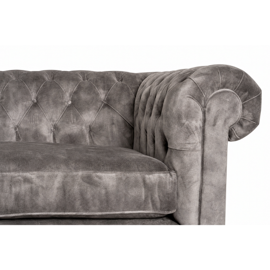 Gray velvet sofa with tufted backrest on a white background