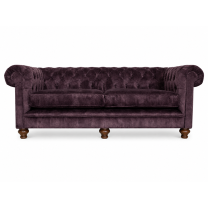 Purple velvet sofa with wooden legs on a white background