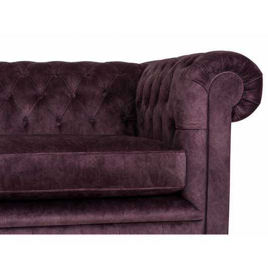 Purple velvet sofa with tufted backrest on a white background