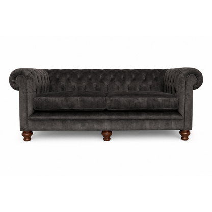 Dark gray tufted sofa with wooden legs on a white background