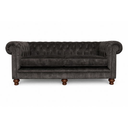 Dark gray tufted sofa with wooden legs on a white background